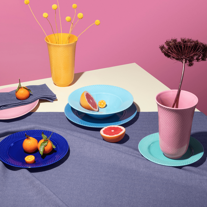 A grouped arrangement of Lyngby Porcelæn white porcelain vases, bowls and candle holders, showing the ribbed grooves of the 1936 Lyngby Vase.