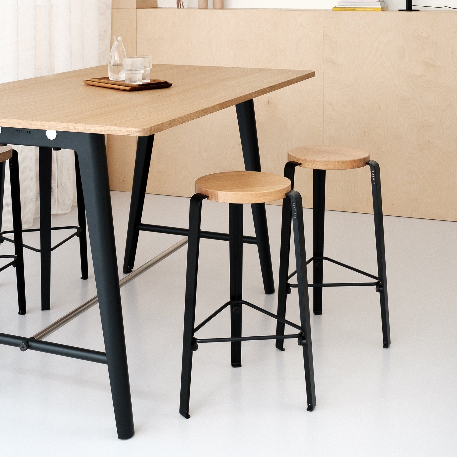 Tiptoe steel-and-oak furniture styled in a Paris interior — powder-coated steel legs and solid oak pieces designed to flat-pack and disassemble.