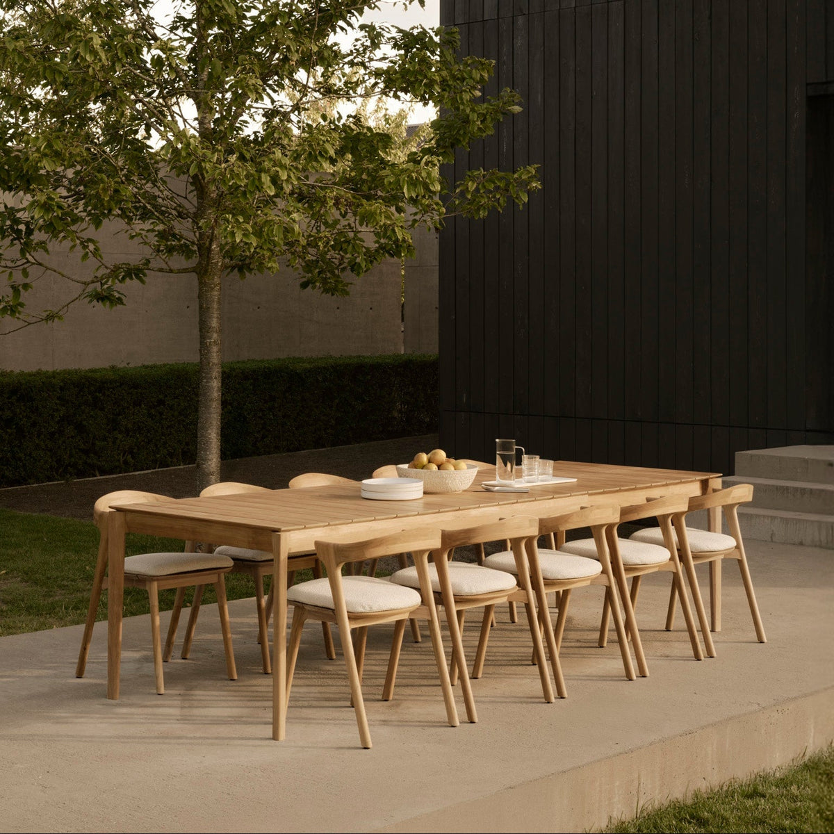 Ethnicraft Bok outdoor extendable dining table in solid teak with cushioned Bok outdoor chairs on a terrace