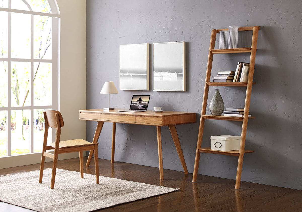 A bamboo desk, chair and ladder shelf in a bright room with framed prints