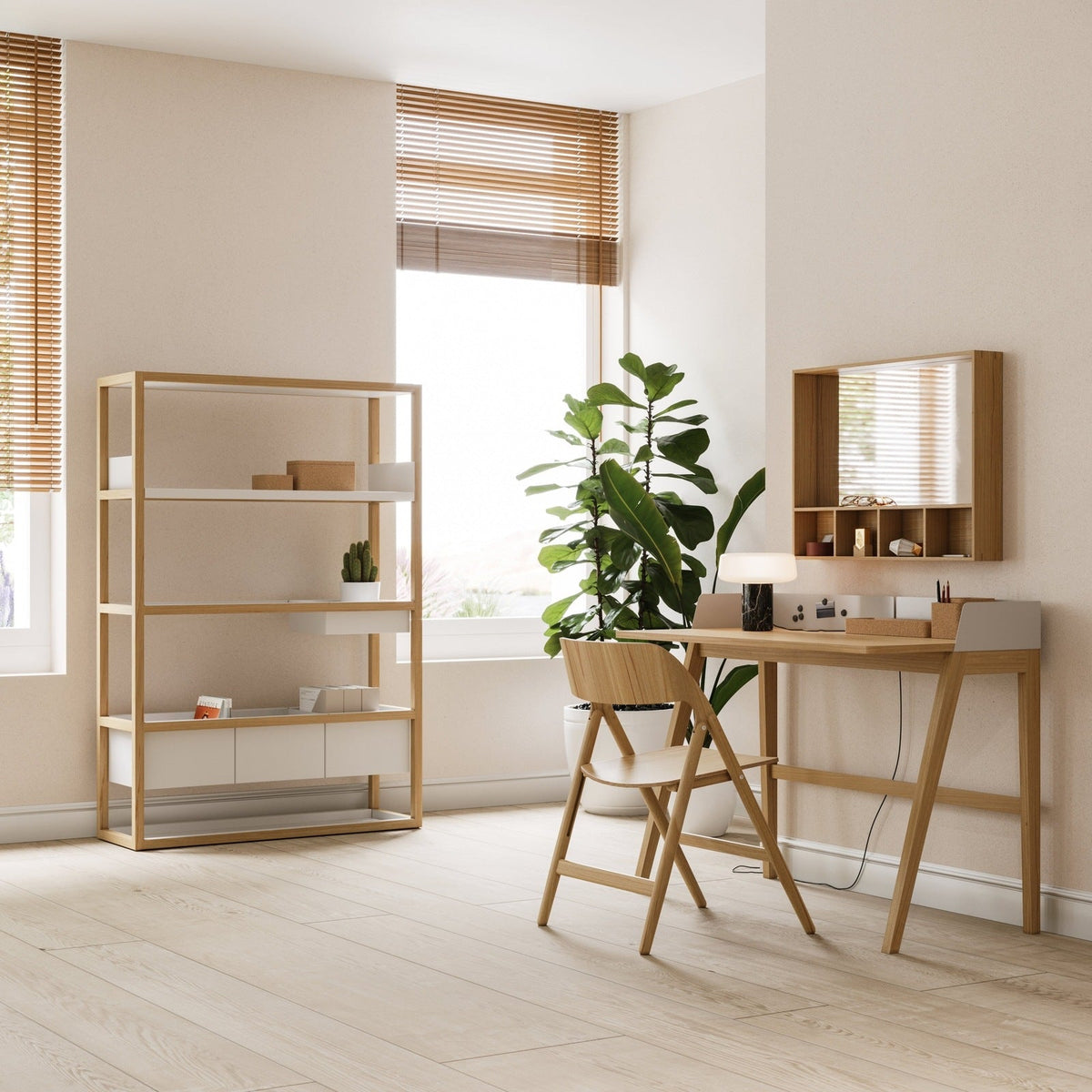 A pale oak desk, shelving unit and mirror in a bright home office with a plant