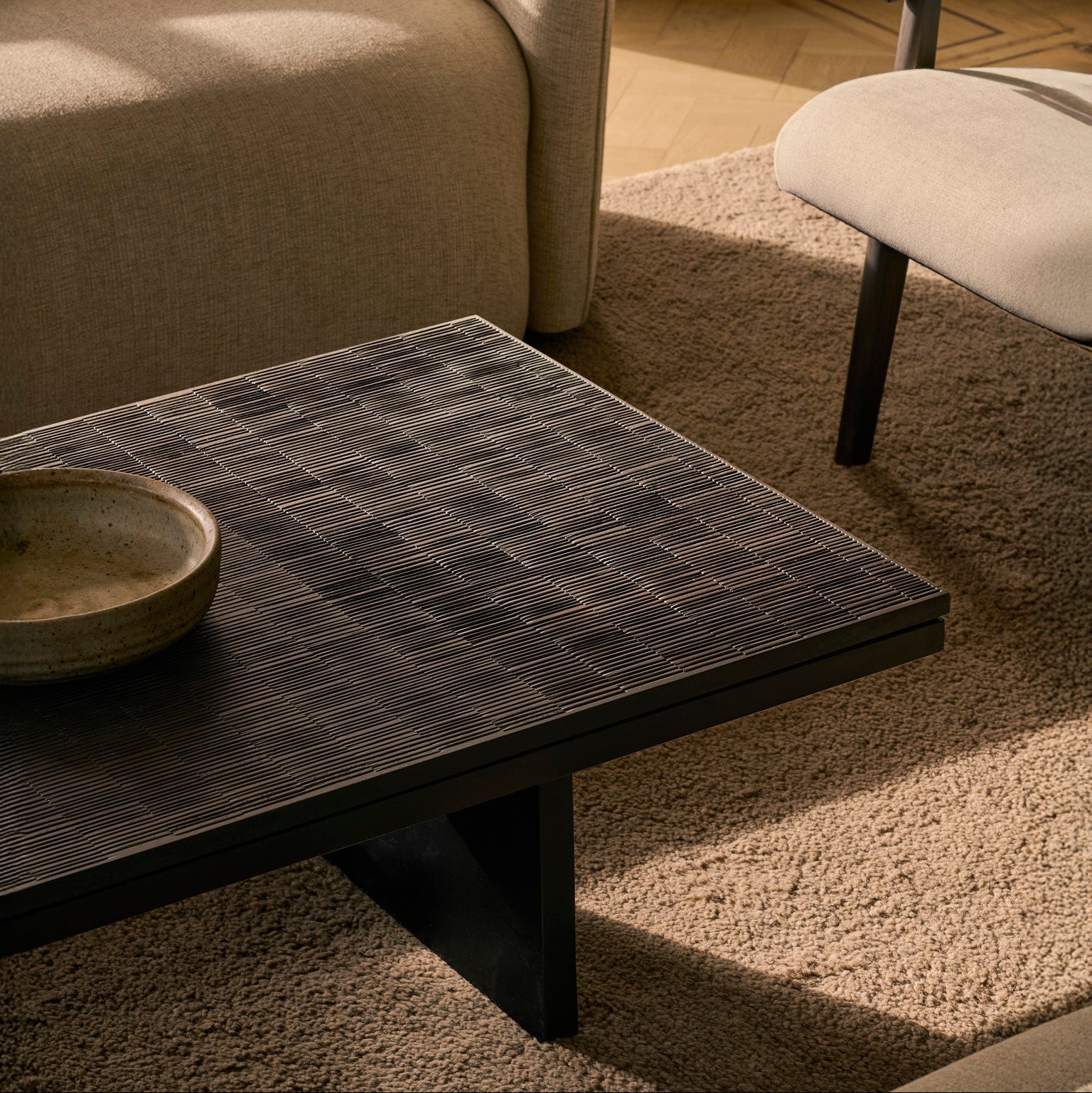 Ethnicraft Grooves Coffee Table with a textured surface in a living room setting.