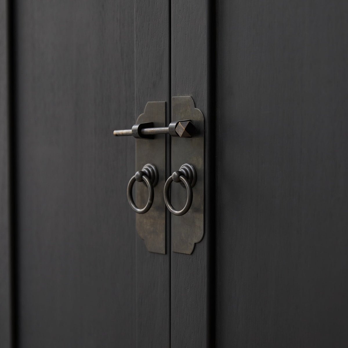 Detail of the Thaki Black cabinet metal door latch and ring pulls