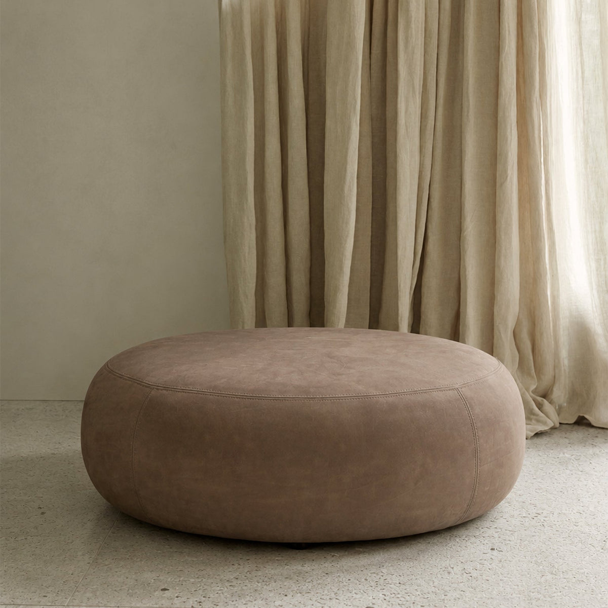 Ethnicraft Orb Pouf in Fawn, styled in a living room, full-aniline nubuck leather