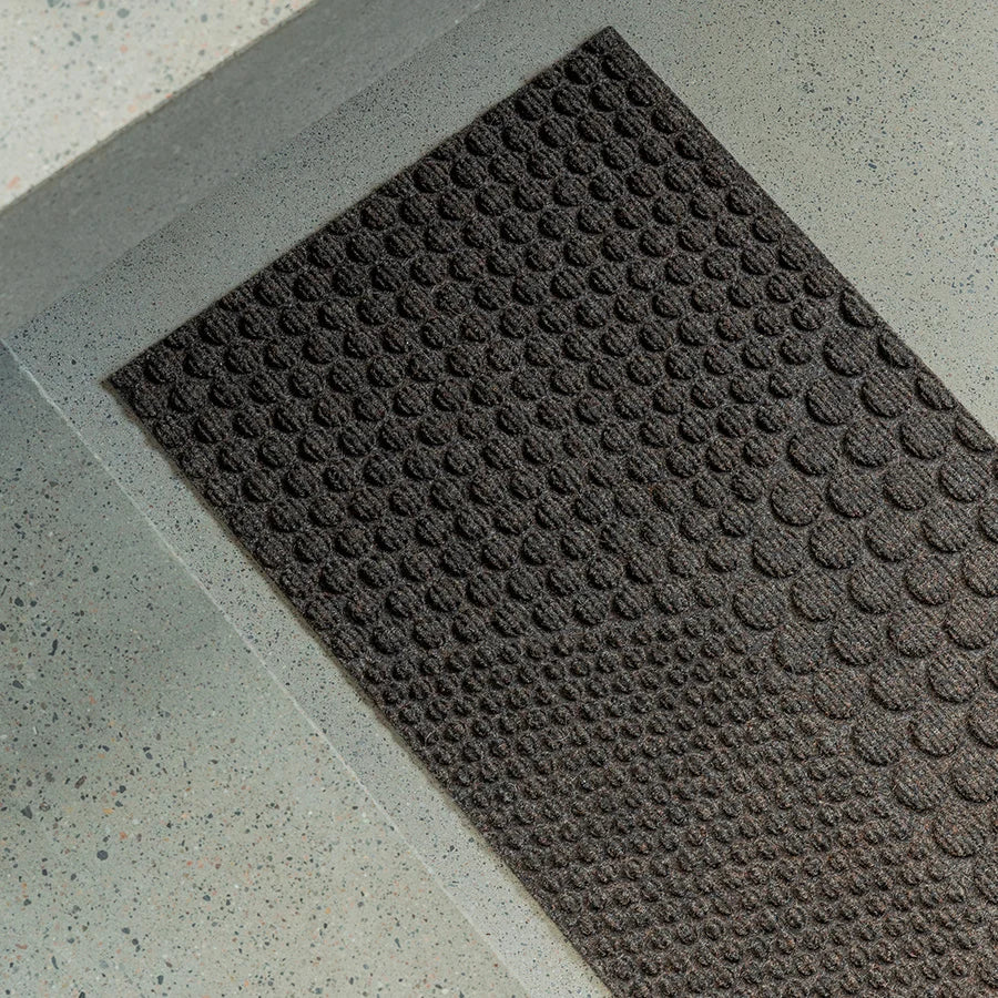 Heymat Hex All Weather Doormat doormat in Soil Brown styled in an entryway, recycled PET yarn Norwegian design