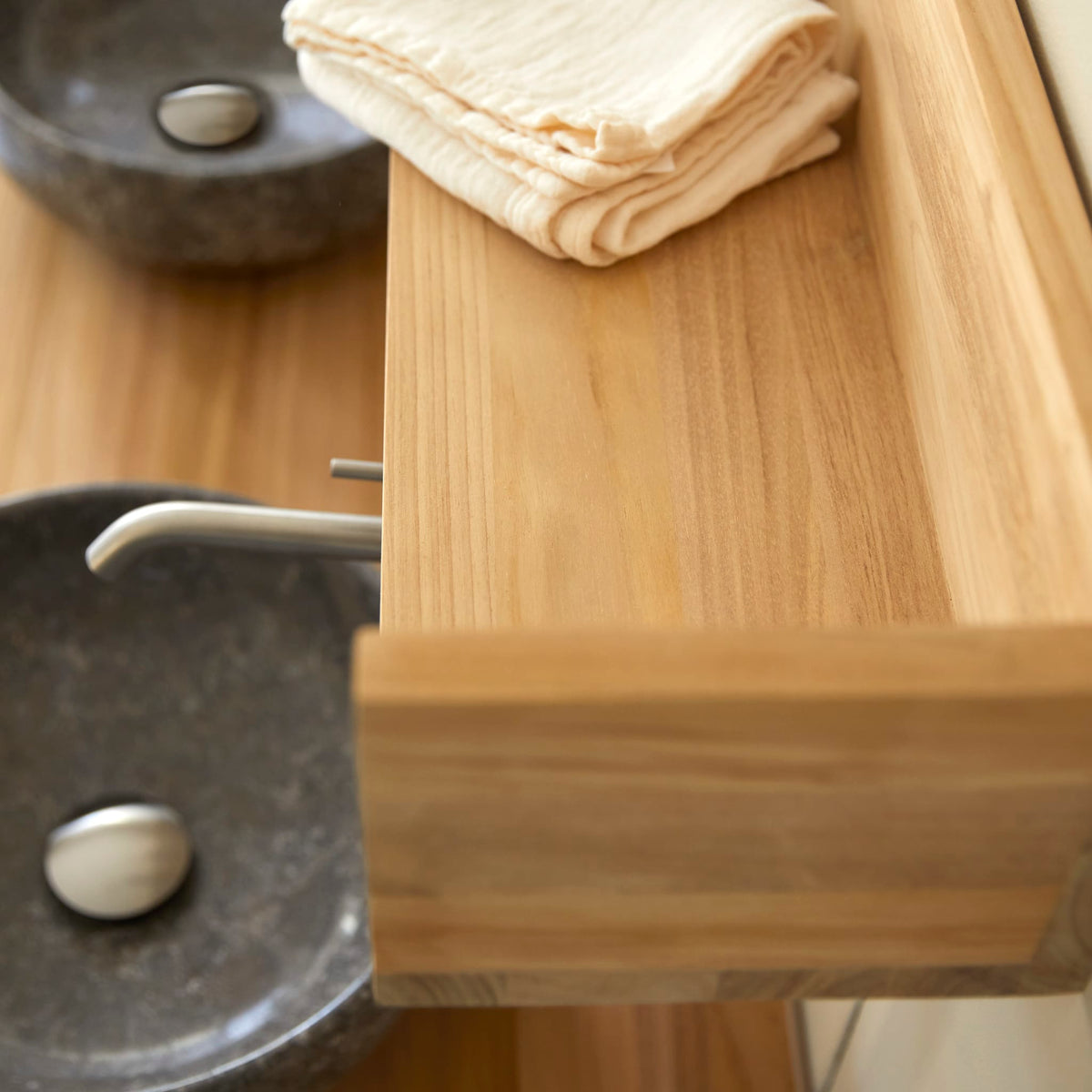Top-down detail of the Arty teak shelf above a stone basin
