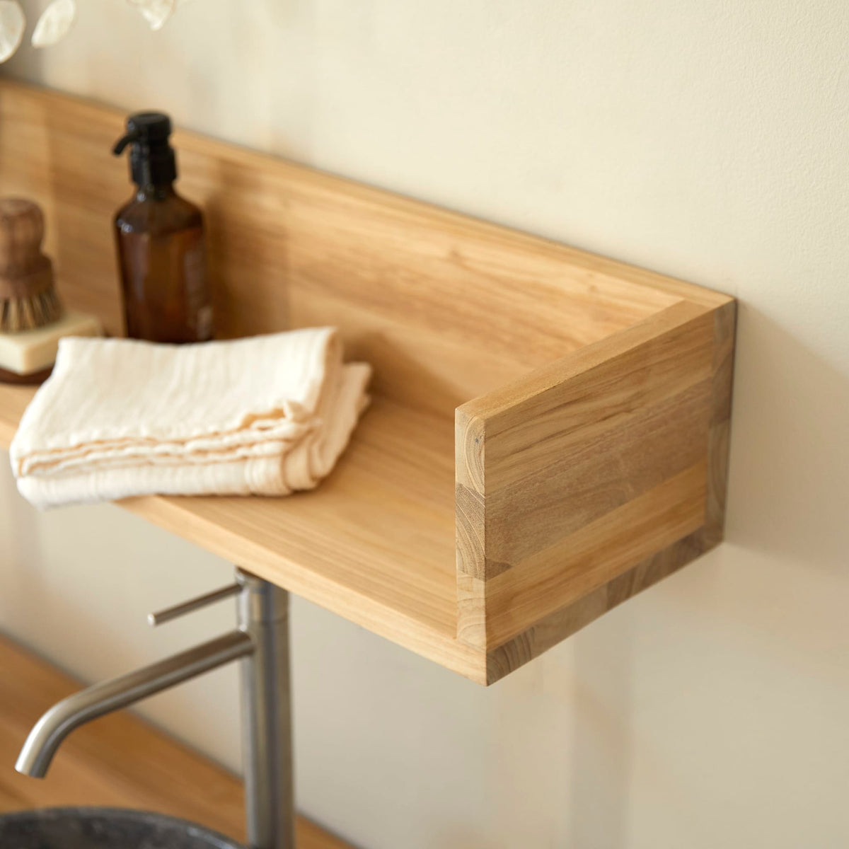 Detail of the Arty teak shelf end panel with a folded towel