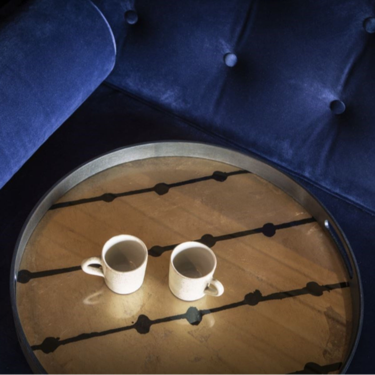Ethnicraft Gold Leaf Dots tray with two cups on a blue velvet sofa