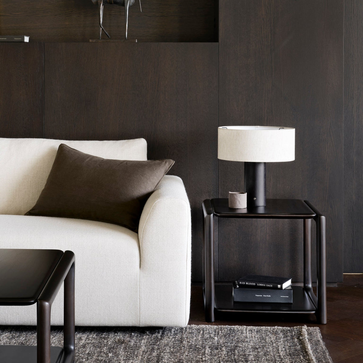Ethnicraft Eda Side Table beside the Ease sofa, styled in an interior setting, solid mahogany