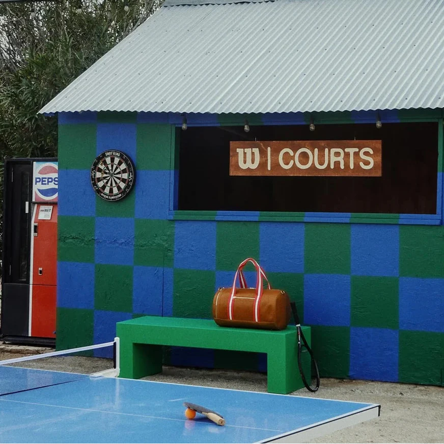 Colorful building with a sign reading 'W Courts' next to a ping pong table.