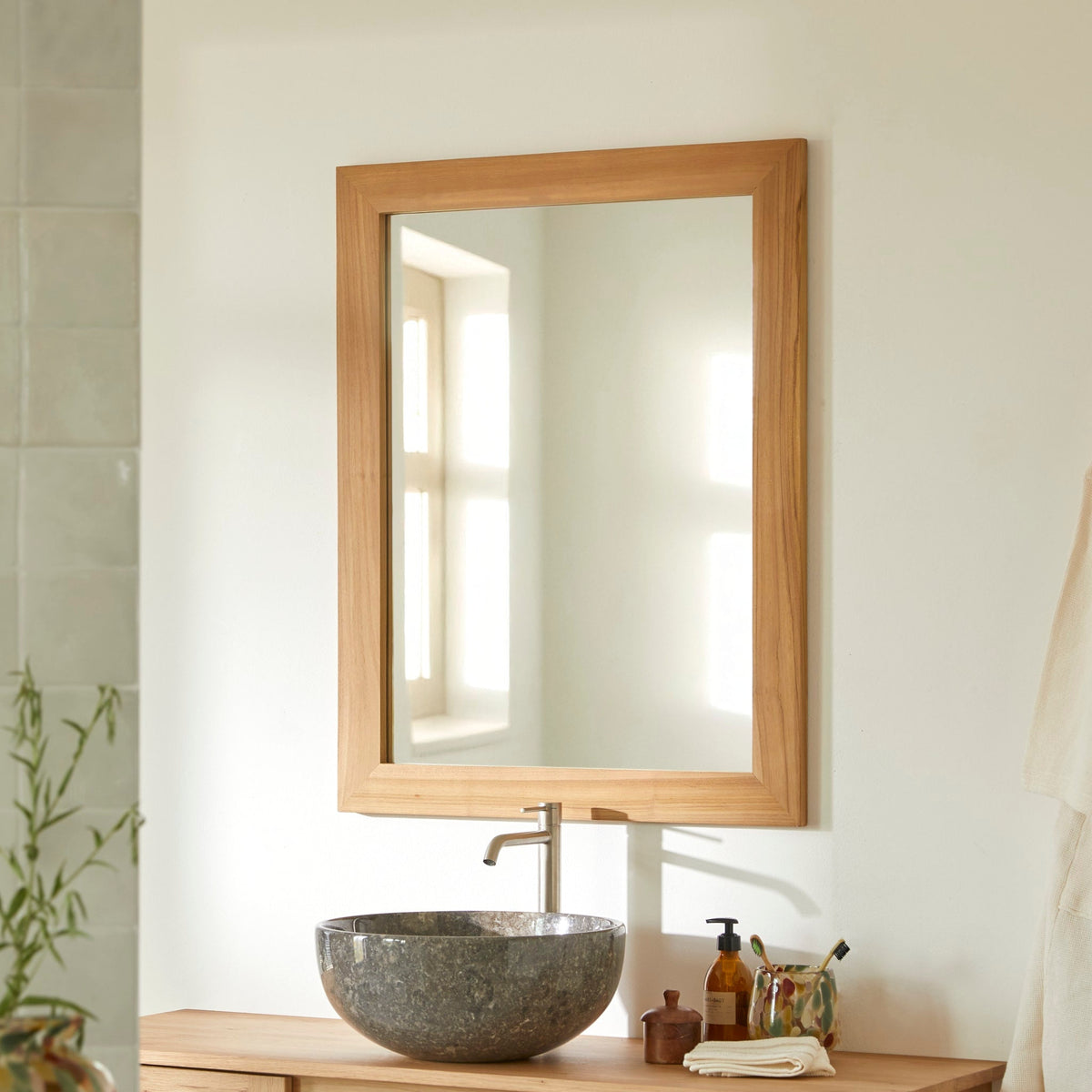 Tikamoon Tona solid teak mirror hung vertically above a stone basin