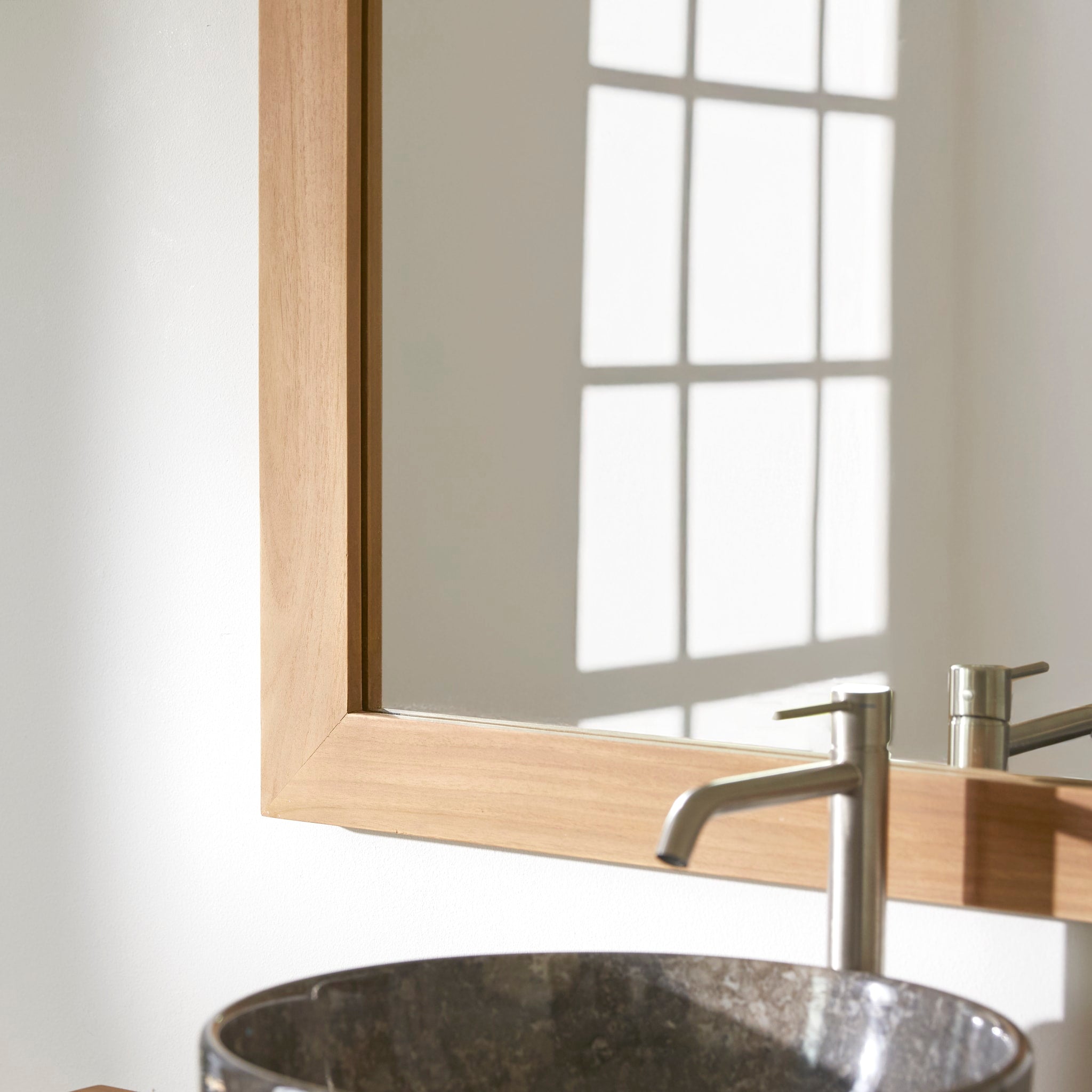 Tona mirror in a bathroom setting with teak furniture