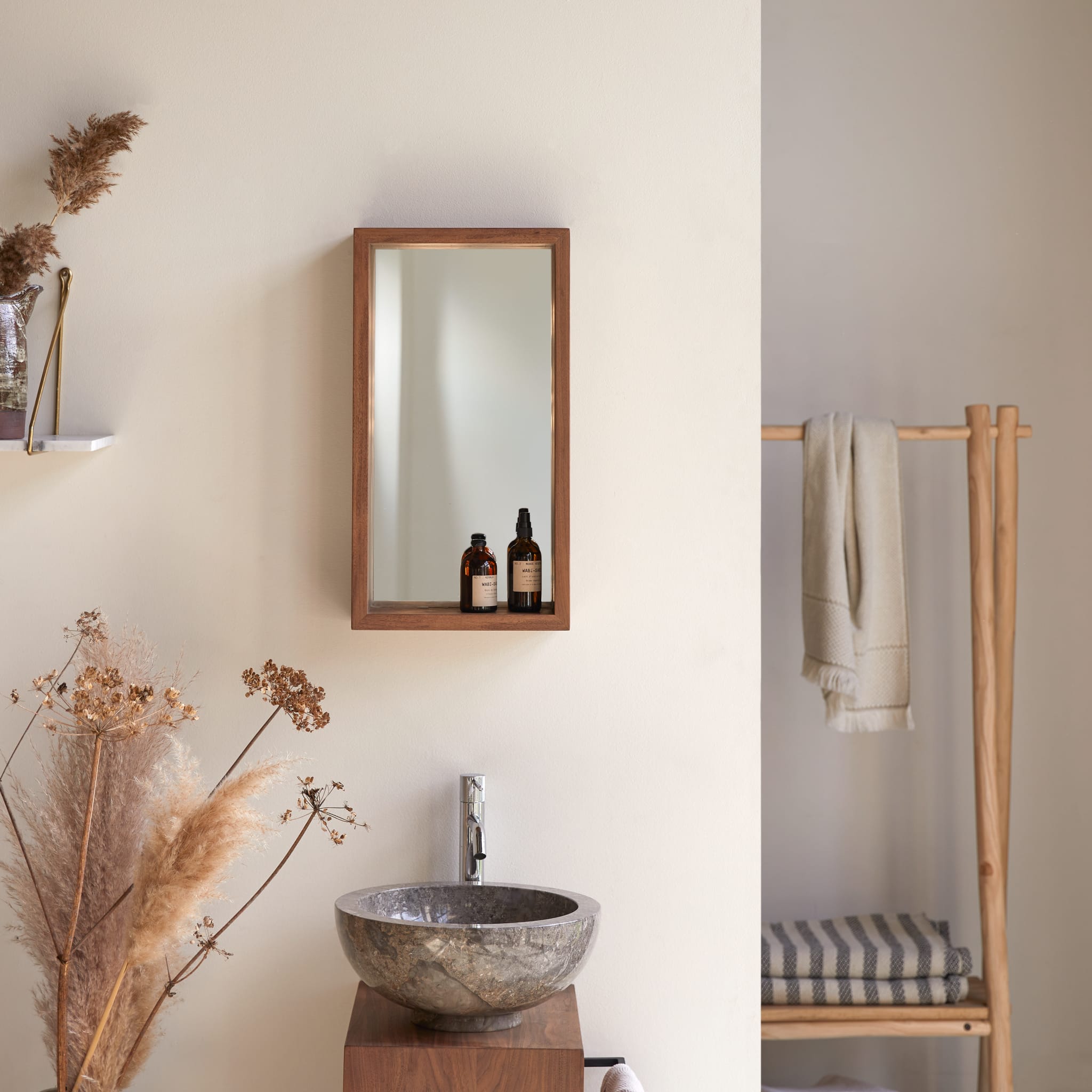 Stelle solid walnut mirror, front view on a white wall