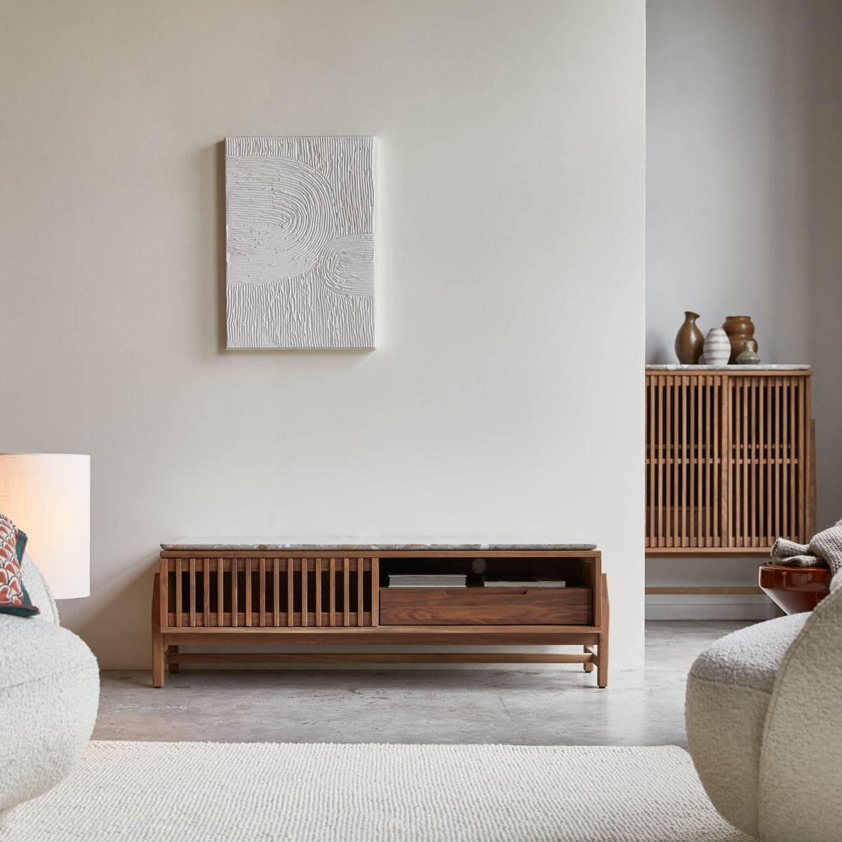 Tikamoon Isaure TV stand in solid walnut with a terrazzo top, angled view