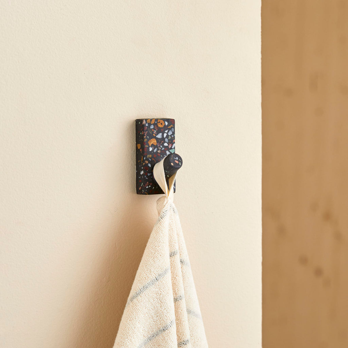 Tikamoon Sara confetti terrazzo hook on a wall in a styled entryway
