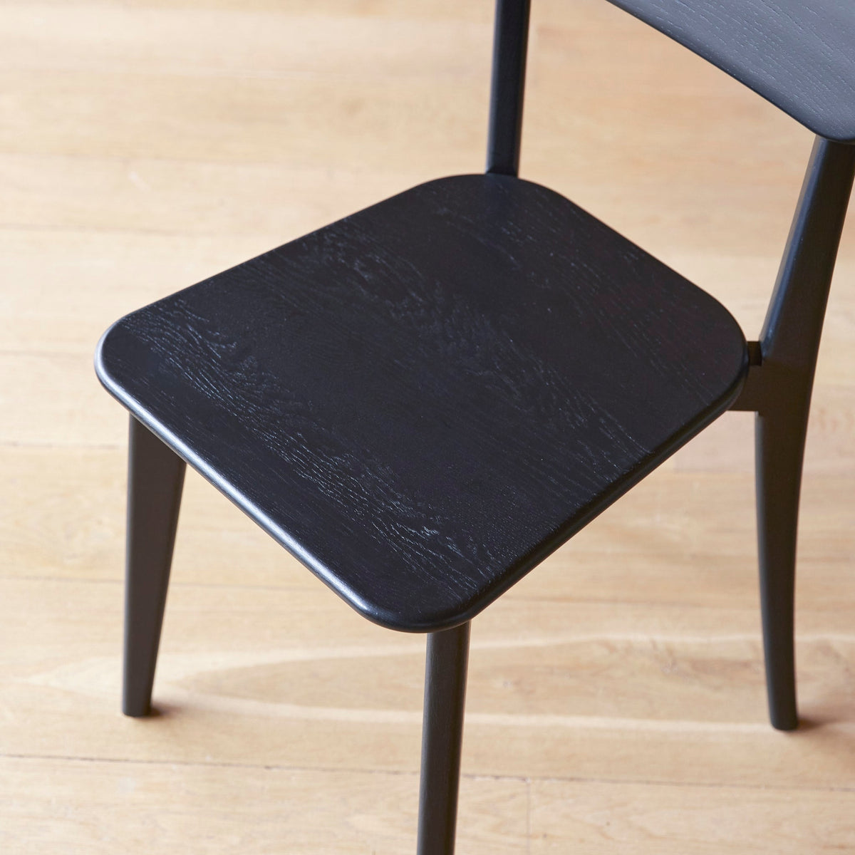 Tikamoon Abel black oak dining chairs, the pair shown side by side