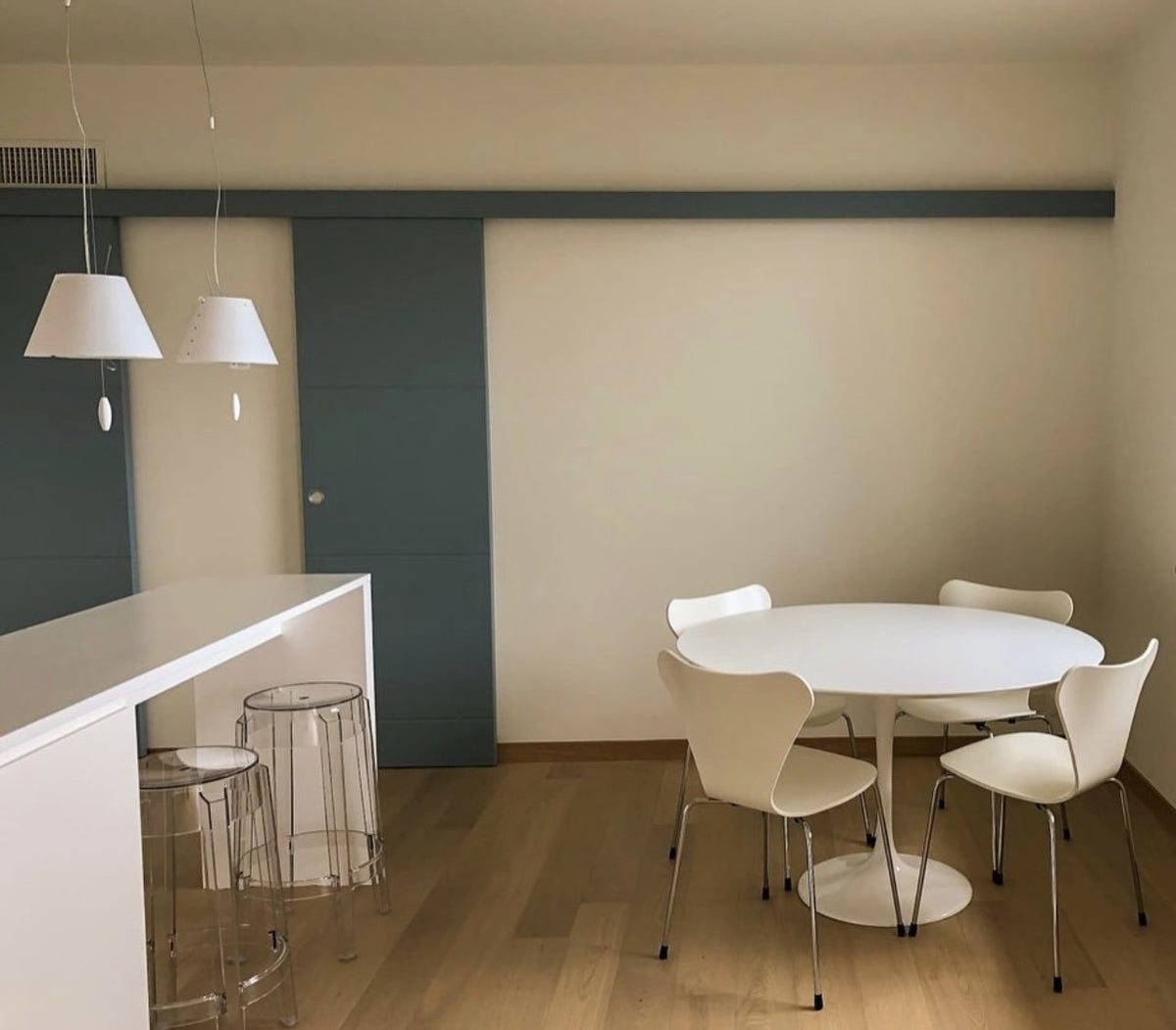 Luceplan Costanzina Pendants over a round dining table, styled in an interior setting