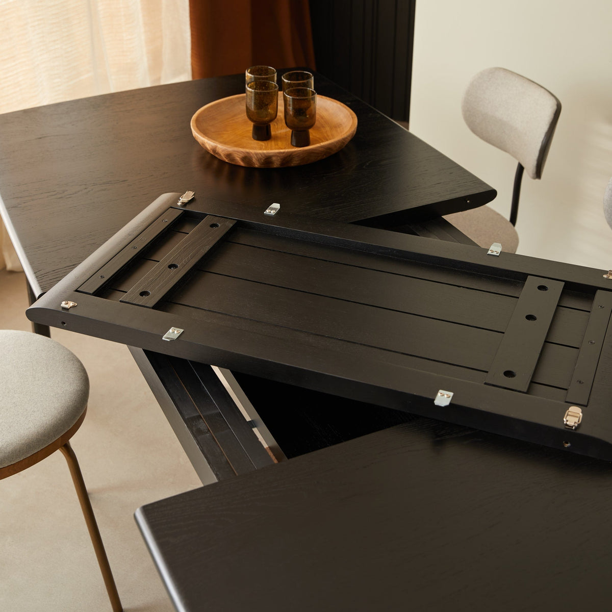 Clara table extension leaf unfolding from under the tabletop