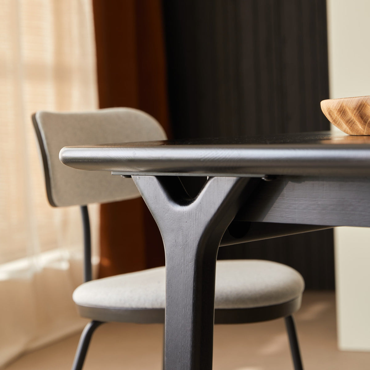 Detail of the Clara table Y-shaped oak leg and exposed joint