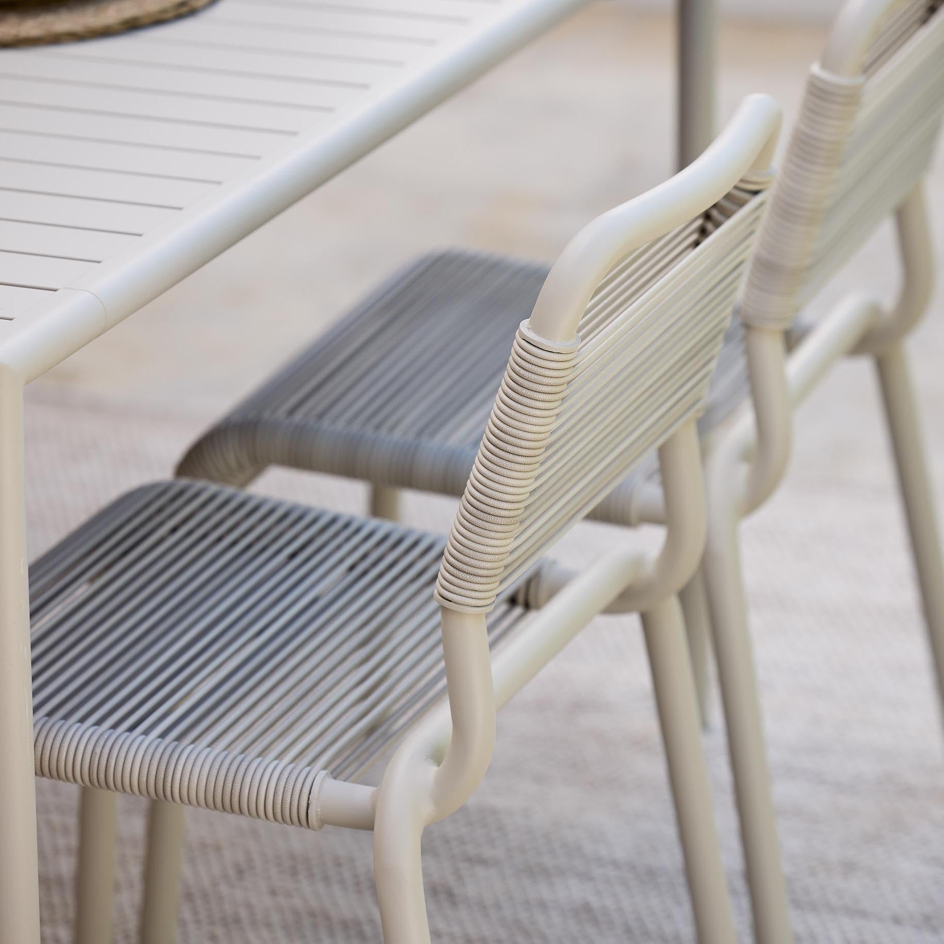 Two outdoor chairs Al Dente by Cane-Line with woven seats on a wooden table.