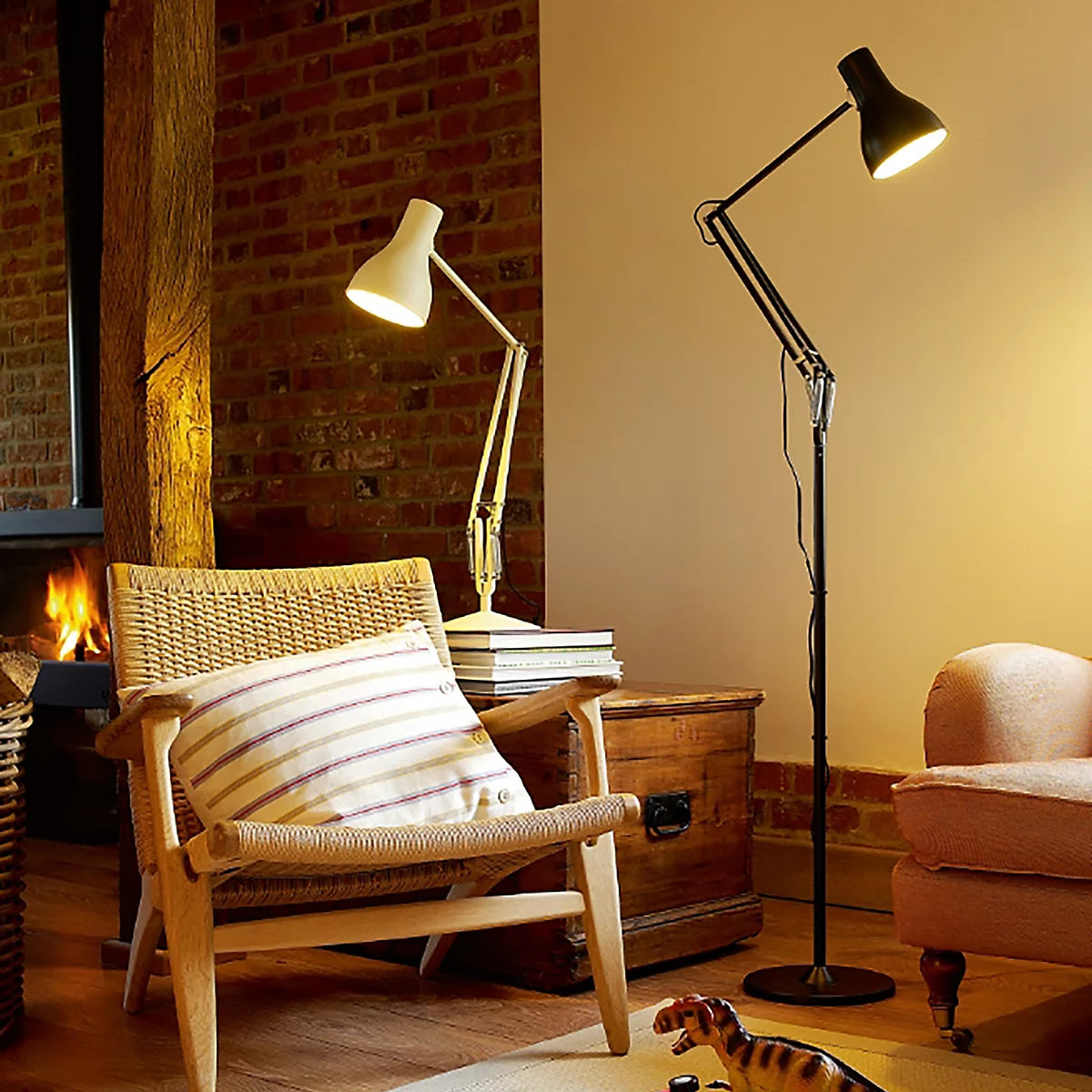 Anglepoise Type 75 floor lamp in black beside a cane armchair by a fireplace