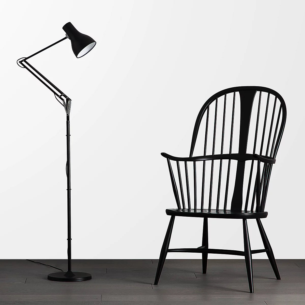 Anglepoise Type 75 floor lamp in black beside a black spindle-back armchair