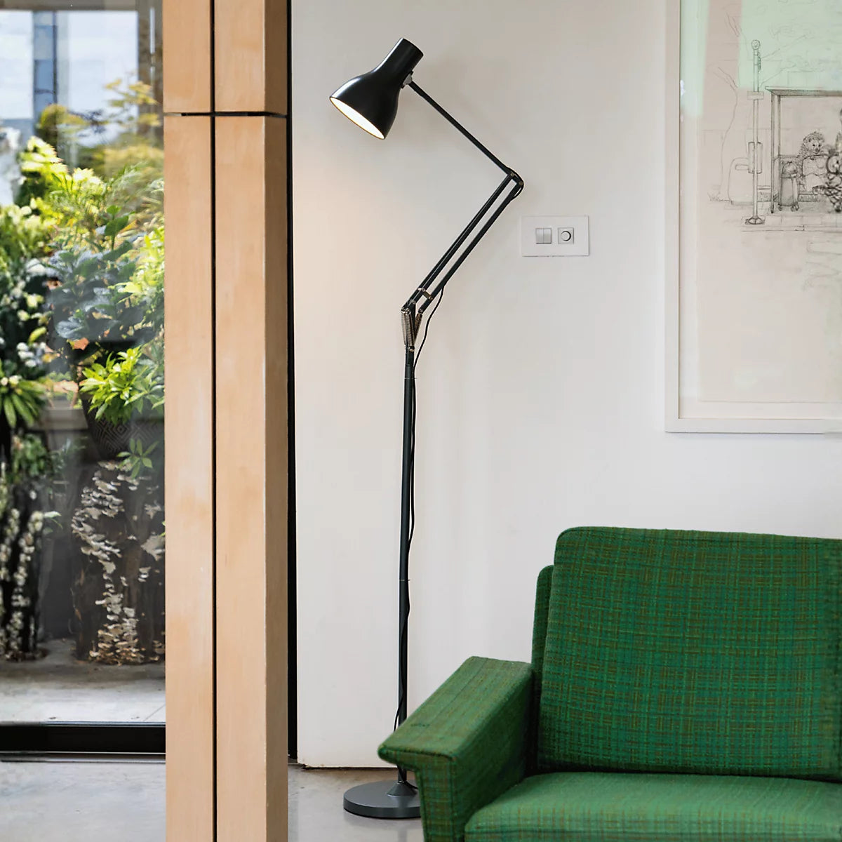 Anglepoise Type 75 floor lamp in black over a green lounge chair