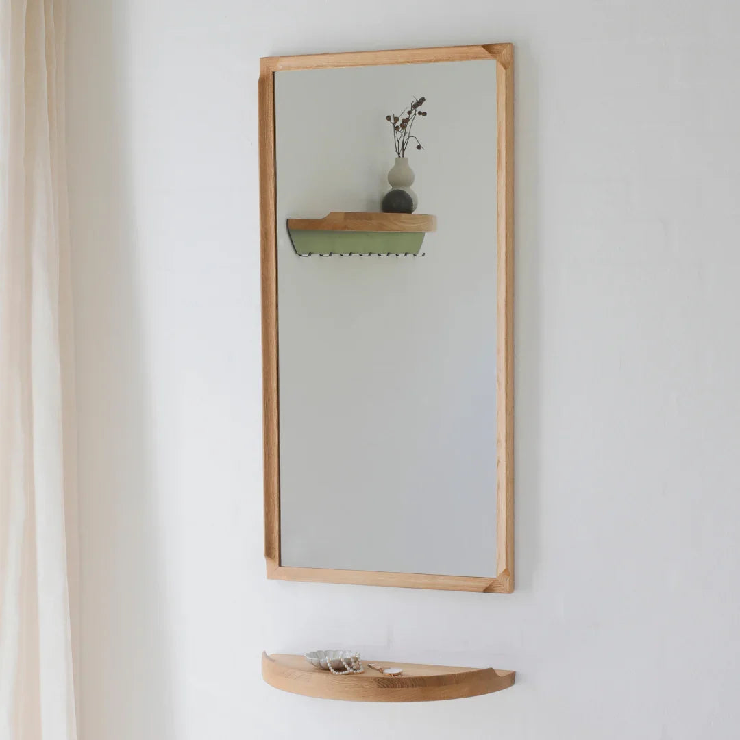 Aakjaer Arcus Mirror in natural oiled oak hung upright in a bright hallway