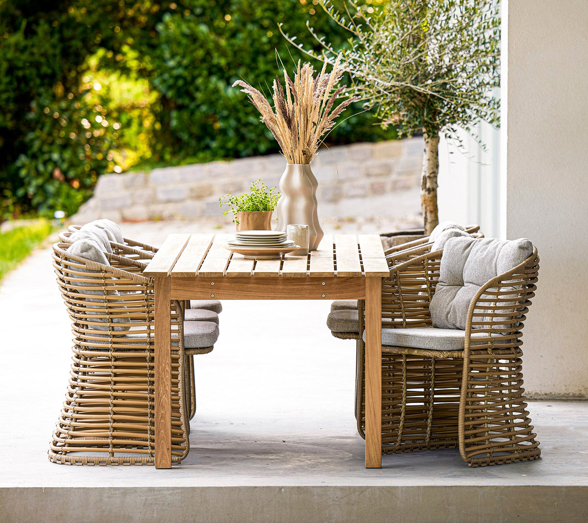 Cane-line Basket Dining Chairs in natural Cane-line Weave around an Endless dining table, styled outdoors