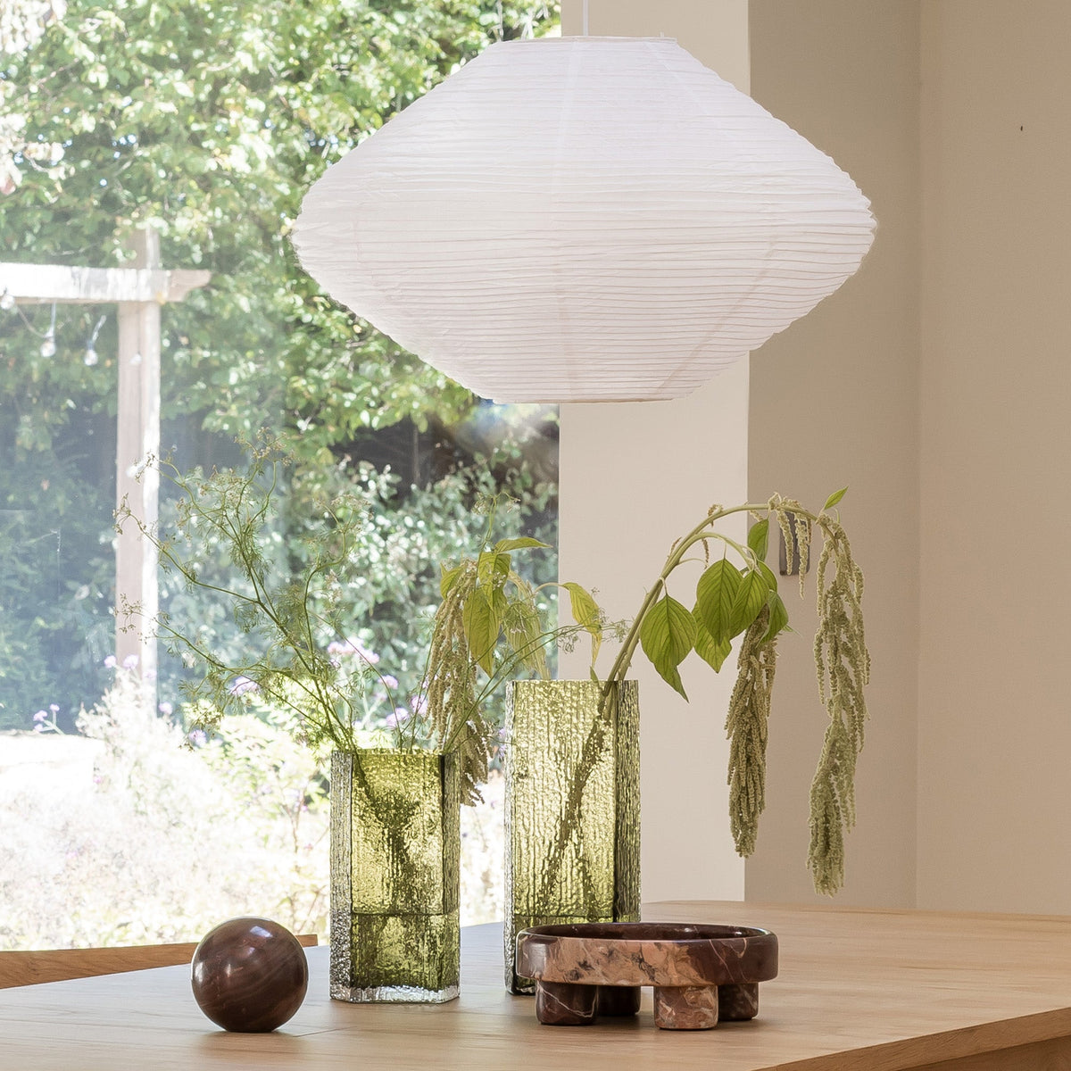 Case Causeway Vase in Olive, two sizes styled on a table beneath a Rubin pendant, blown glass