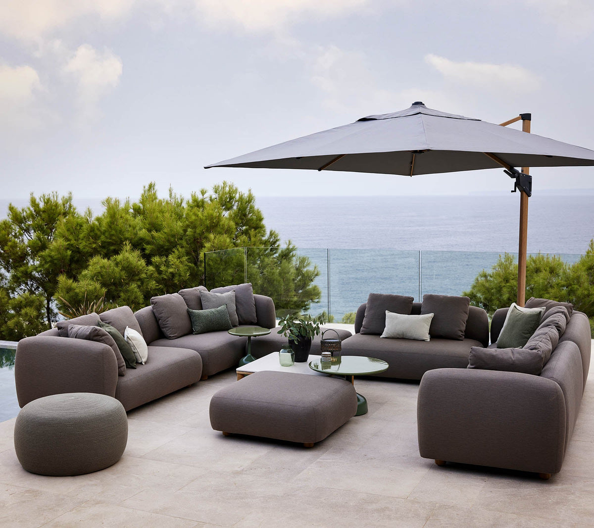 Cane-line Capture lounge in AirTouch acrylic under a parasol, styled on a terrace