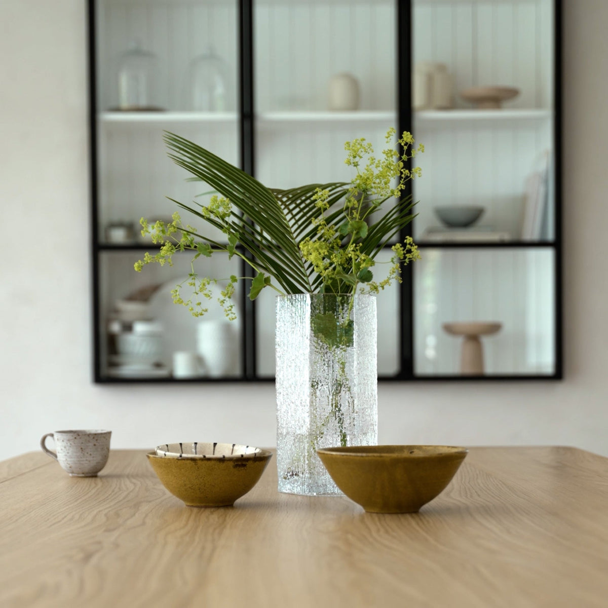 Case Causeway Vase in Clear, styled in an interior setting with greenery, blown glass
