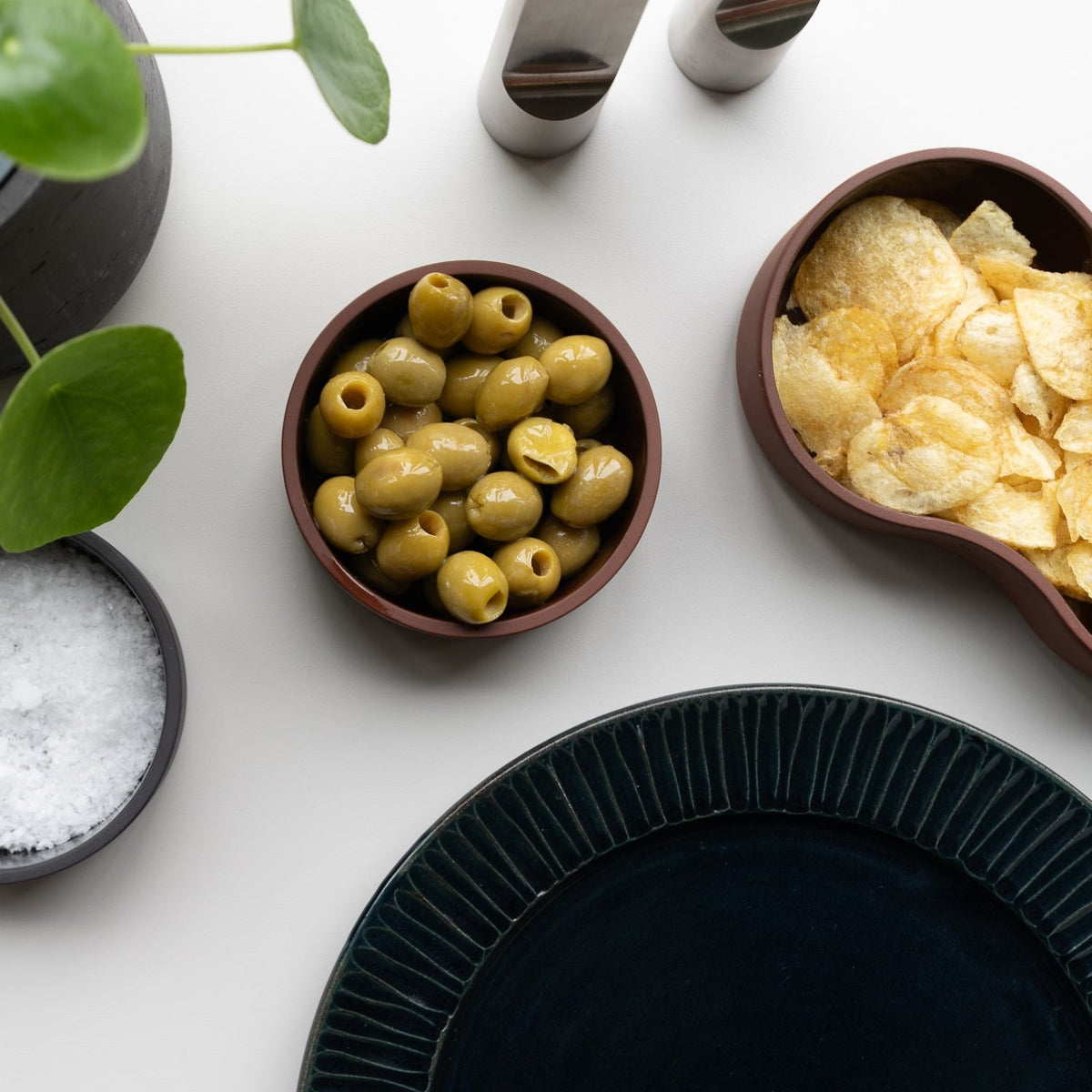 Case Dip Bowl in Brown, styled on a table with olives and chips, solid-colored porcelain