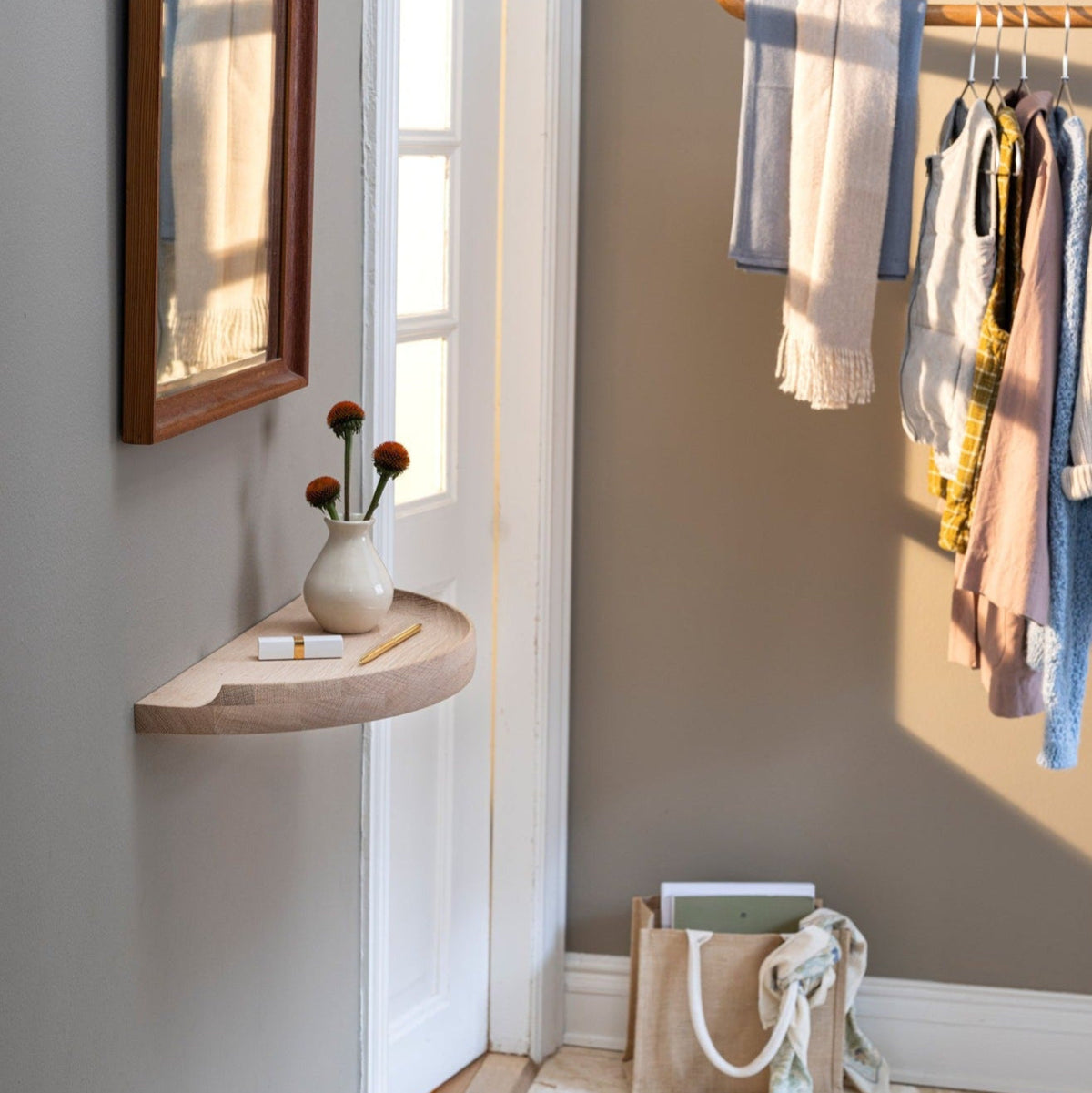 Aakjaer Arcus Console Shelf in white oiled oak in a hallway with a mirror and a clothes rail