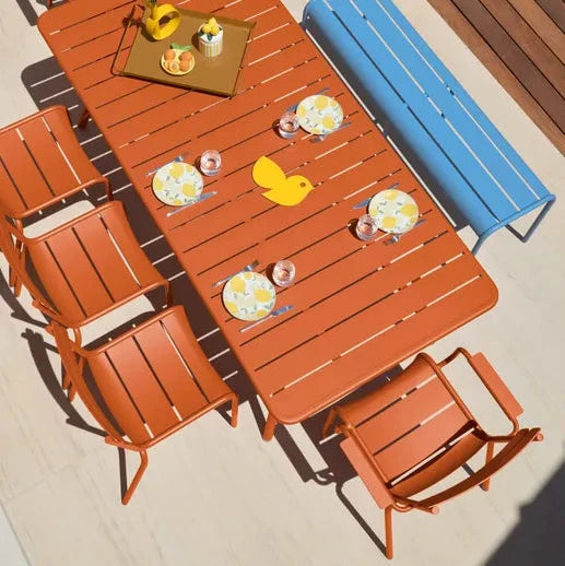 Fermob Luxembourg Side Chair in Candied Orange styled in a Mediterranean setting, the Luxembourg garden chair