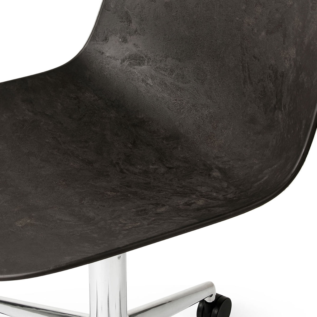 Detail of Mater Eternity Swivel Chair with Wheels in Coffee Waste Black showing the flecked surface of the recycled composite