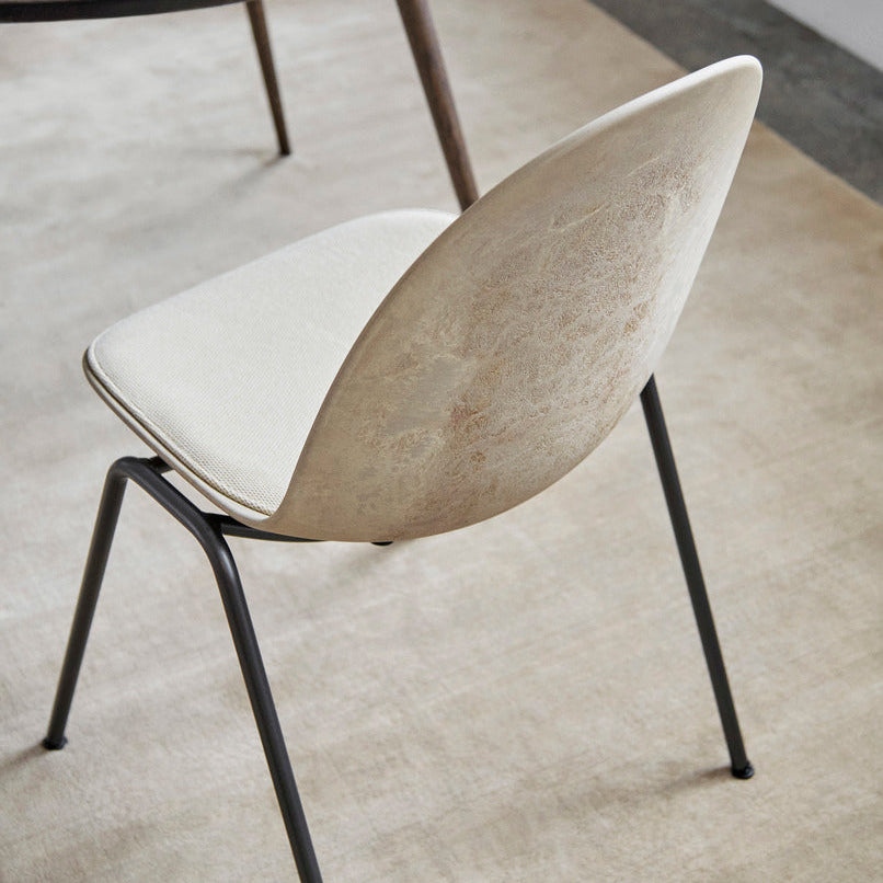 Detail of Mater Eternity Side Chair in Coffee Waste Light showing the molded edge of the recycled composite shell
