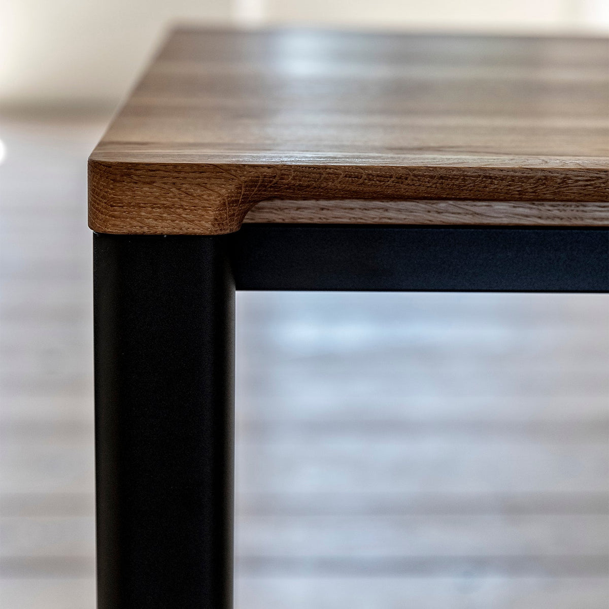 Detail of Bent Hansen Meet Dining Table showing the oak top corner and leg profile