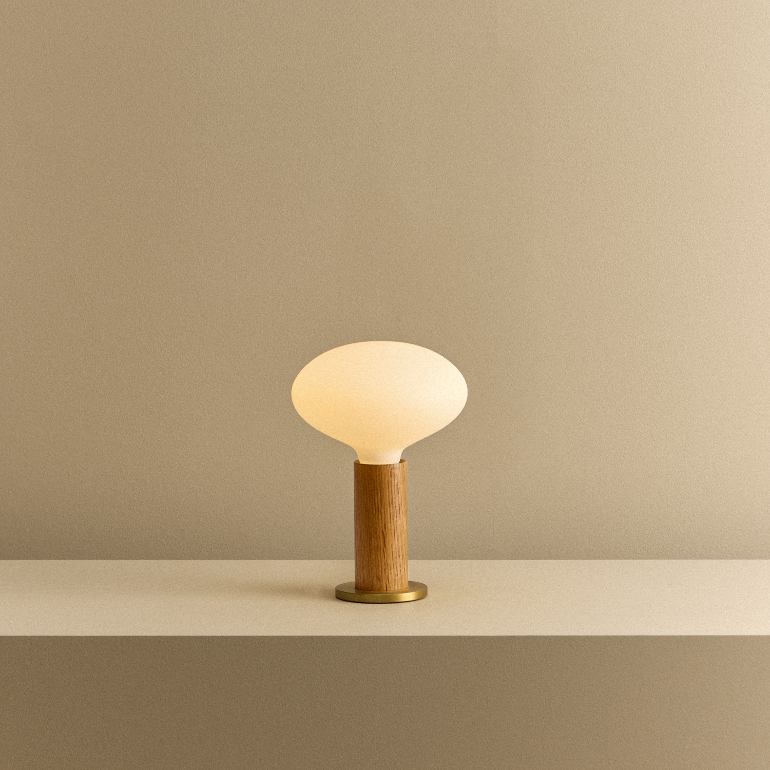 Knuckle Table Lamp in Oak with Oval Dim to Warm bulb, illuminated