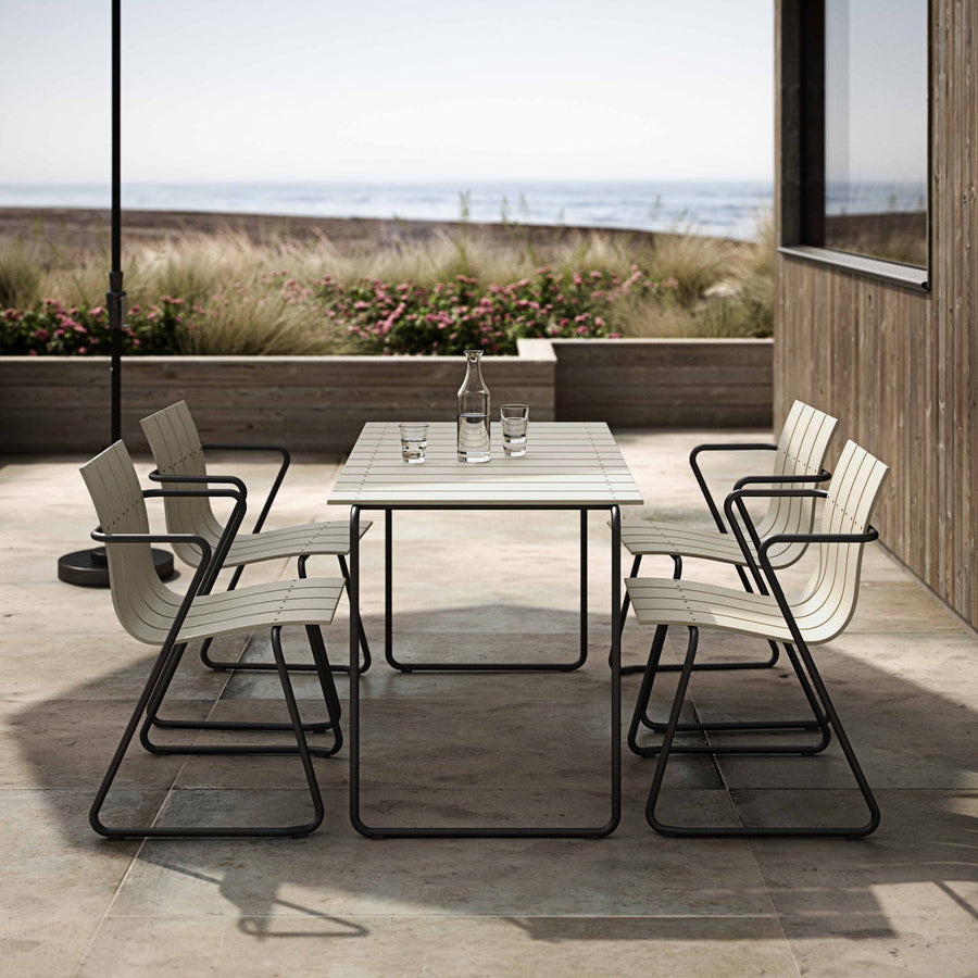Mater Ocean 4 Person Dining Table styled in an outdoor setting, slats of recycled plastic waste