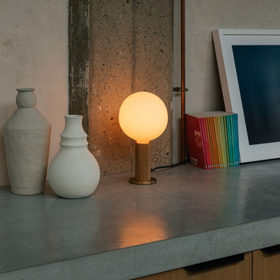 Tala Knuckle table lamp with Sphere IV bulb in Oak solid oak with hand-blown glass bulb styled in a styled interior