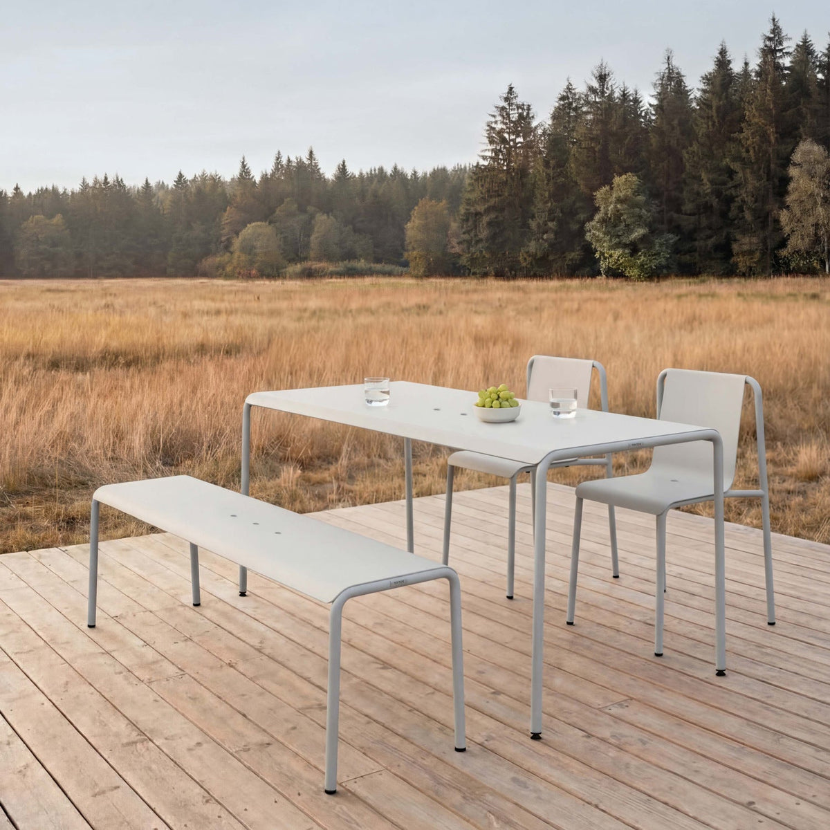 Tiptoe PANORAMA Outdoor Chairs in Chalk Gray with a matching table and bench on a deck, powder-coated steel
