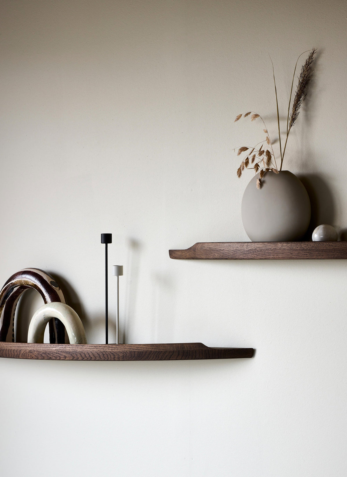 Aakjaer Arcus shelves in smoked oak styled with ceramic arches and a vase