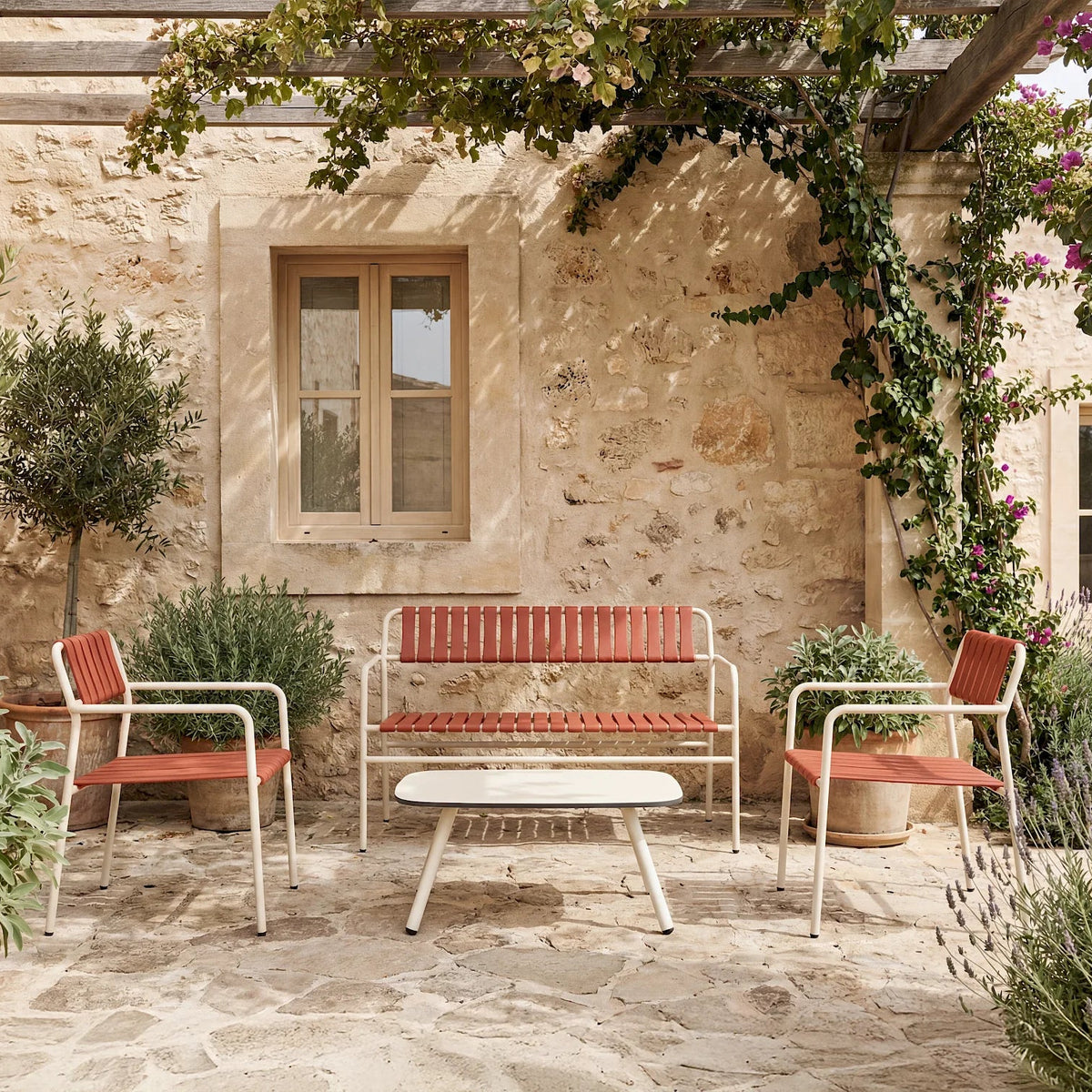 Resol Gelato bench and lounge chairs with Greda terracotta slats on Nácar frames on a stone terrace