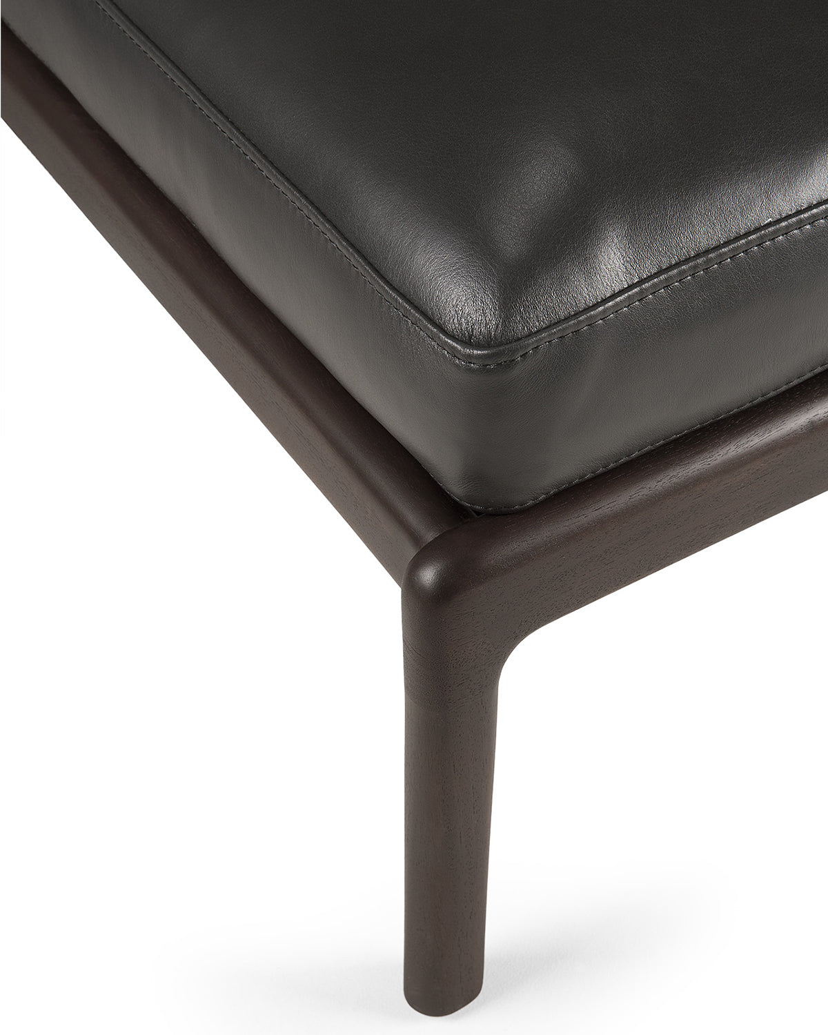 Detail of Ethnicraft Jack Footstool showing the Carbone leather cushion on the mahogany frame