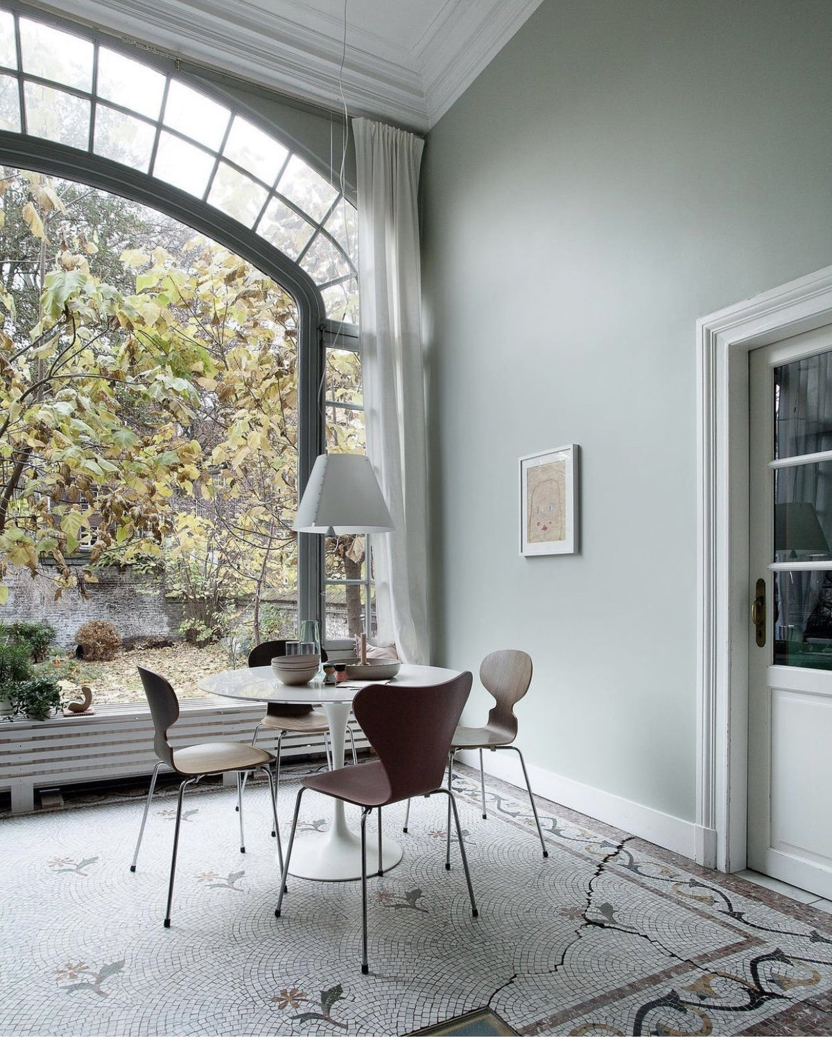 Luceplan Costanza Pendant over a round dining table by a tall window
