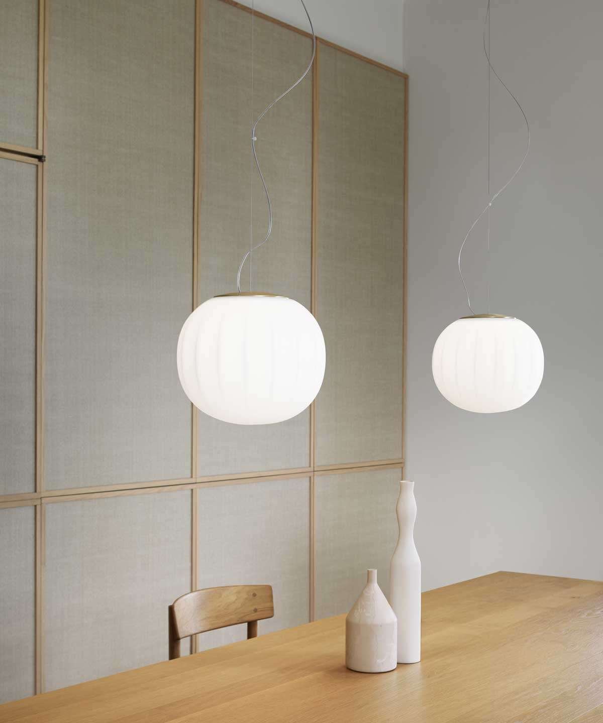 Luceplan Lita Pendants with opal glass globes over a wooden table