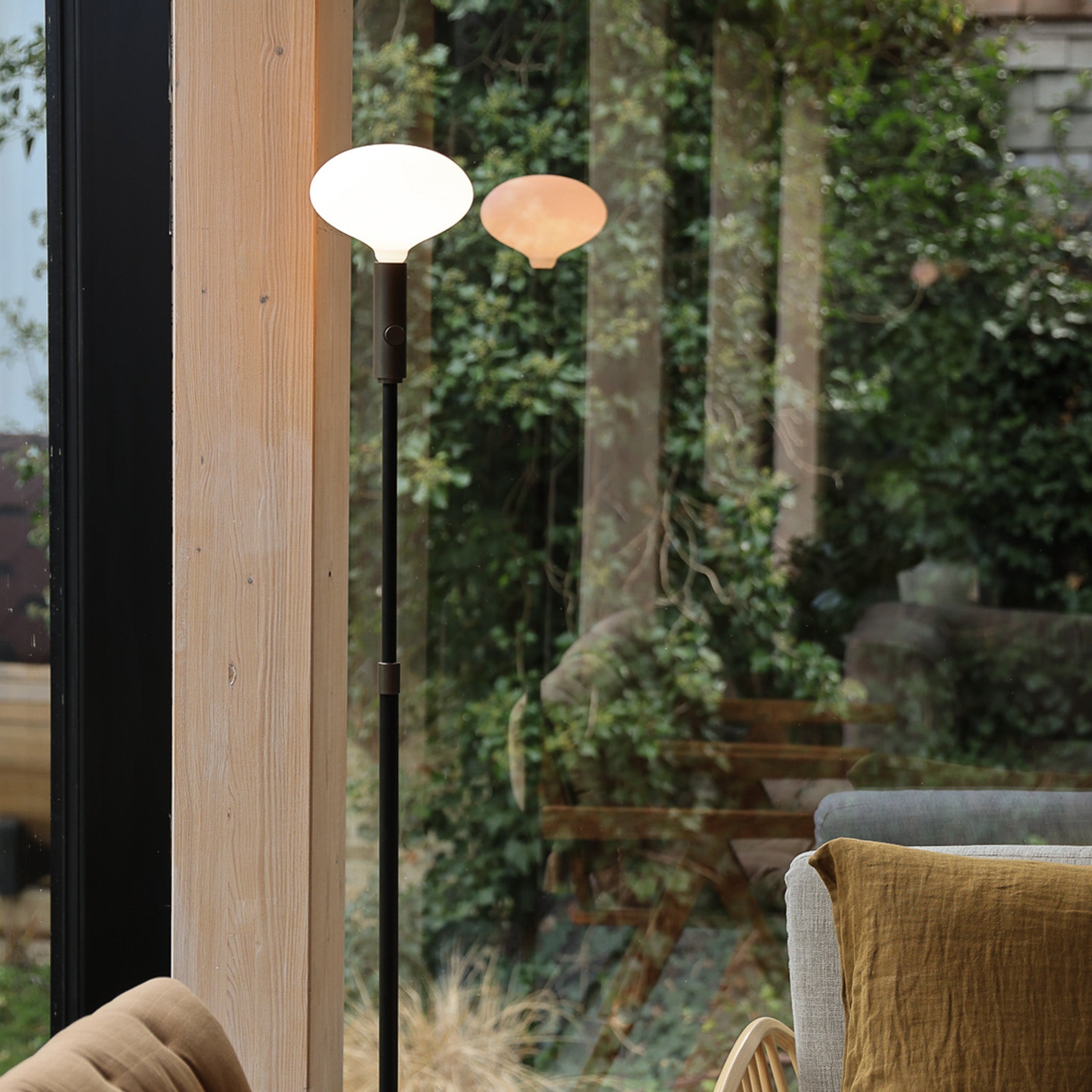 Tala Poise Adjustable Floor Lamp in Graphite with Oval II bulb, reflection lifestyle setting