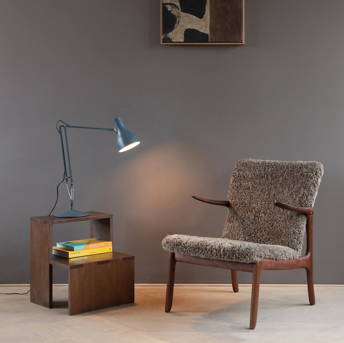 Anglepoise Type 75 desk lamp in Slate Grey on a side table beside a shearling armchair