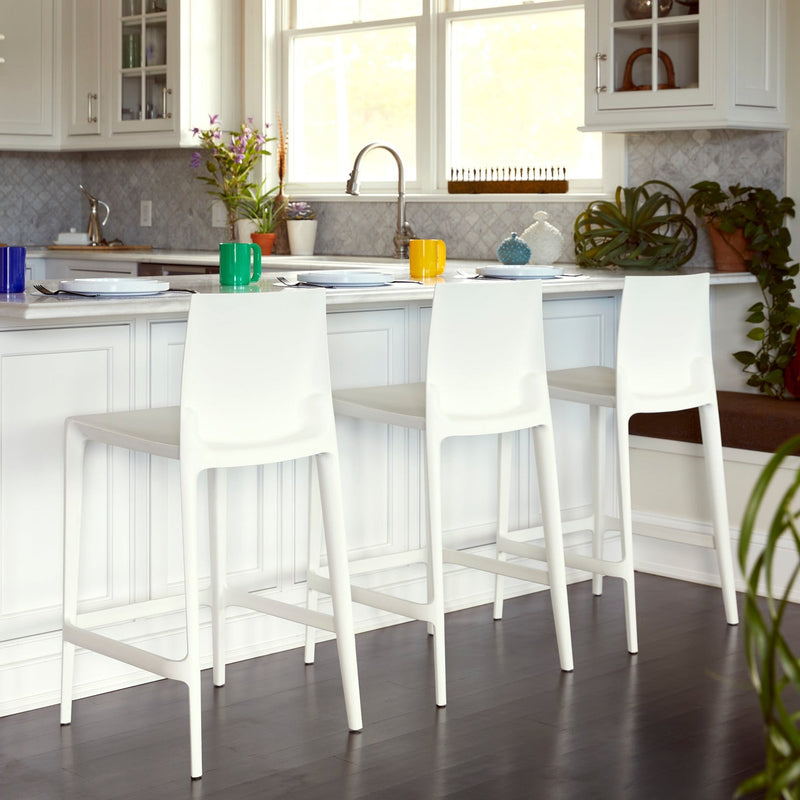 Three white Heller Bellini counter stools at a white kitchen island